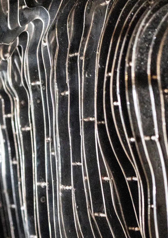 Close-up of the irregular stainless-steel profiles and connecting spacers.