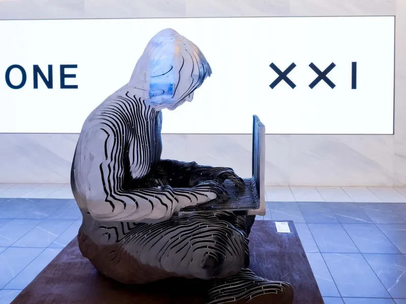 Satoshi sculpture at the New York Stock Exchange, seen from the side in front of the Twenty One Capital wall.